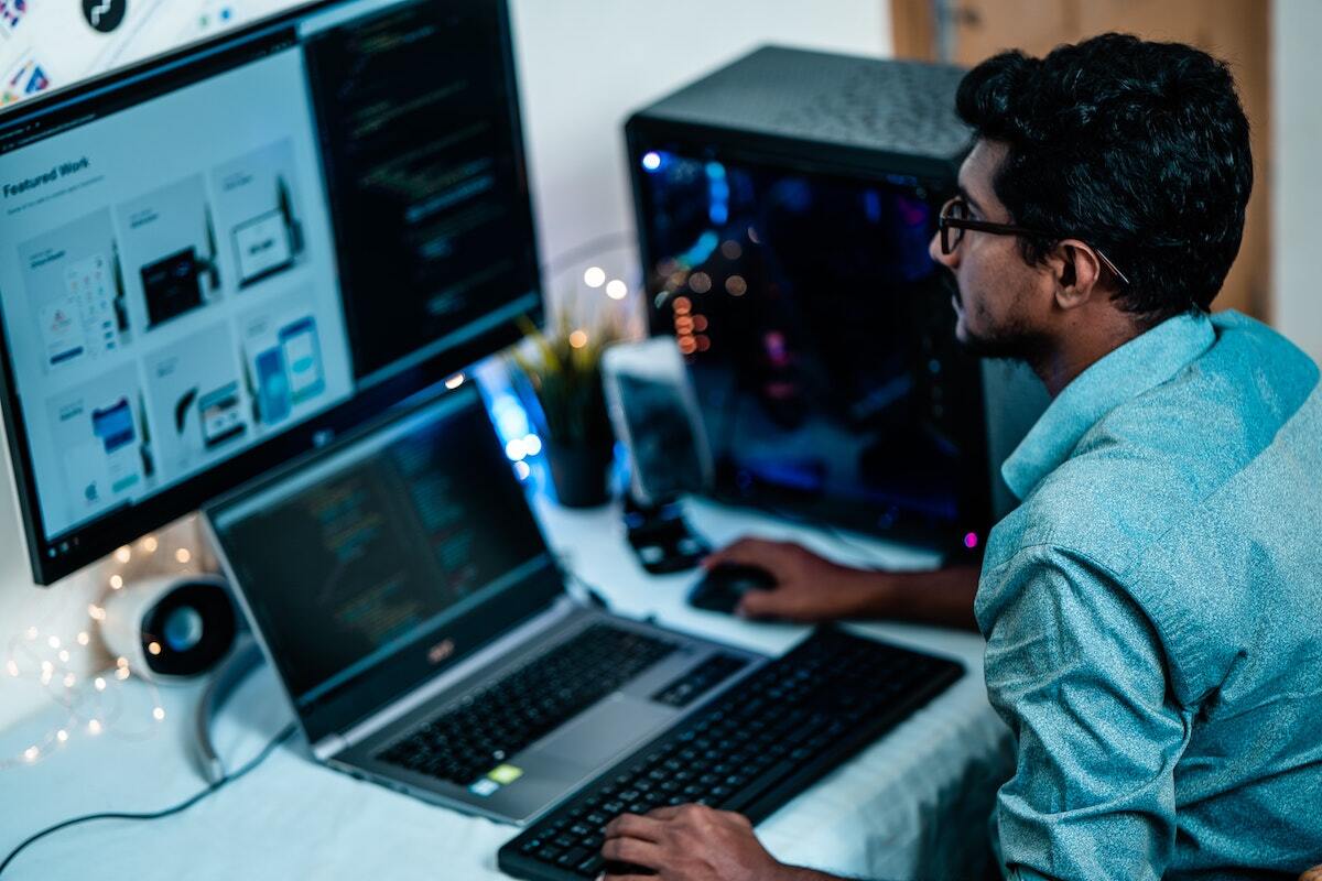 man working with a laptop and monitor
